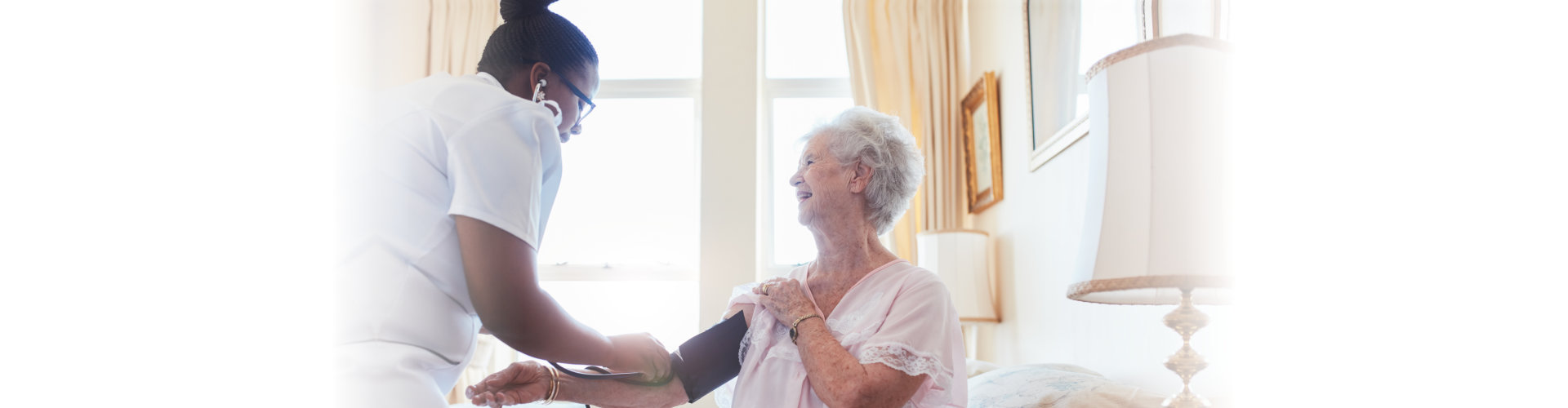 nurse taking senior woman's blood pressure